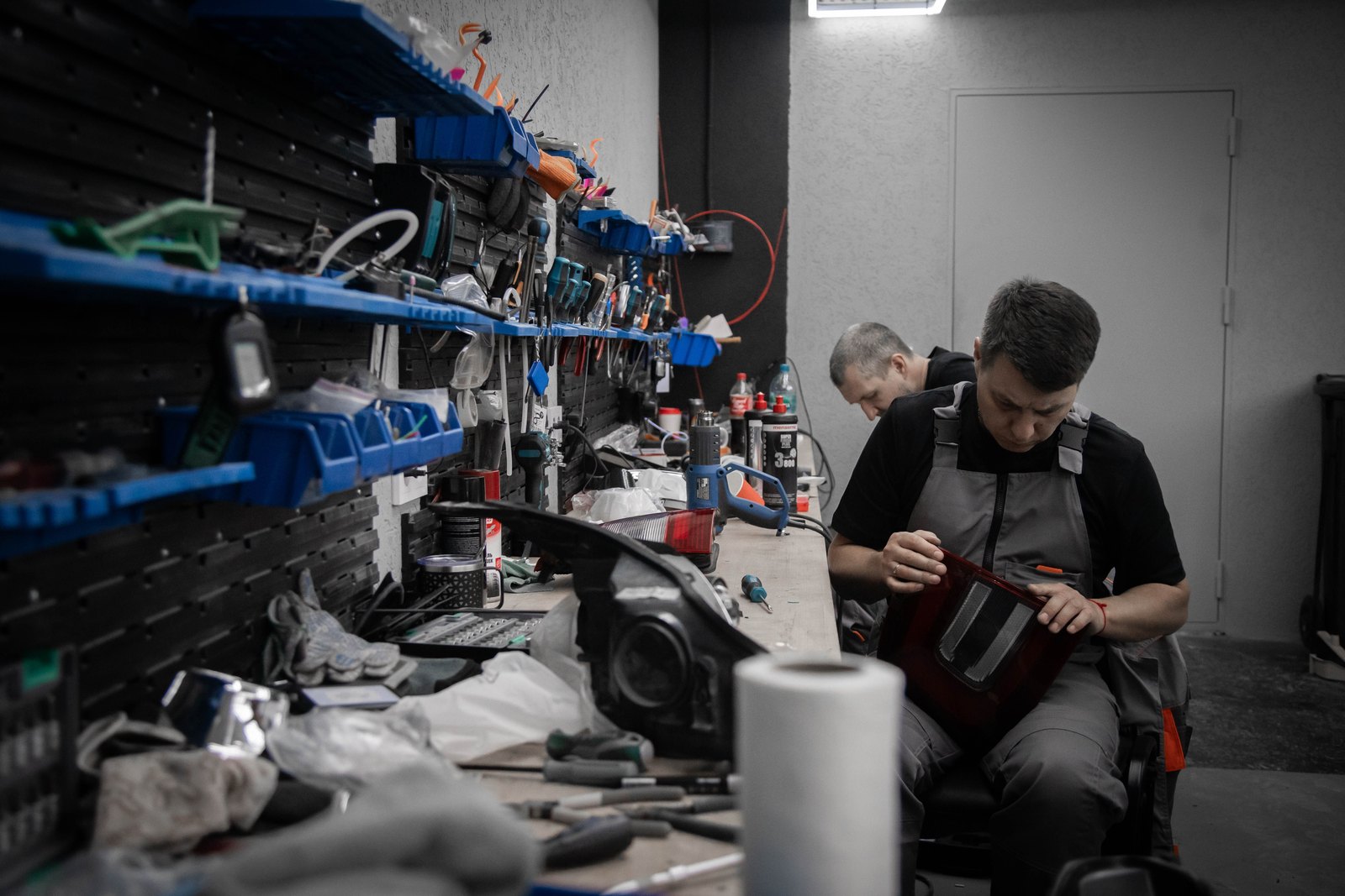 Установщик BAZA разбирает фару на верстаке